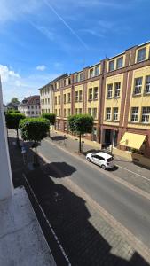 a white car parked on a street with buildings at Auszeit Tor zur Eifel in Euskirchen
