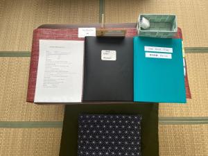 a table with a notebook and a box of papers at One Point Five in Tokyo