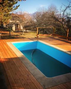a blue swimming pool on a wooden deck at Villa à Gap in Gap