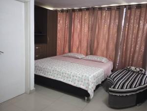 a bedroom with a bed and a window with pink curtains at Apartamento lechería in El Morto de Barcelona