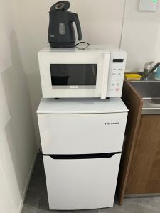 a microwave oven sitting on top of two white servers at One Point Five in Tokyo