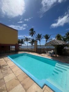 a swimming pool with a view of the ocean at Pousada Chalés do Cunhaú in Canguaretama