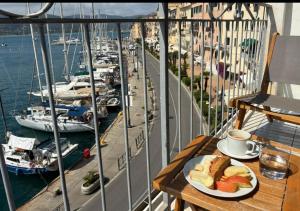 a plate of food on a table on a balcony with boats at Monolocale La Darsena in Portoferraio