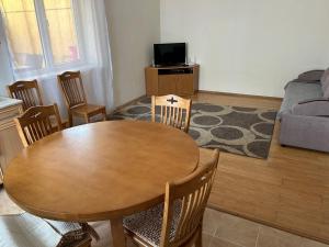 a living room with a wooden table and chairs at Lovely House in Cholpon-Ata