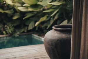 a vase sitting on a table next to a pool at MIZU Boutique Villas - Unique stay in Uluwatu in Uluwatu