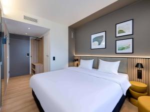 a large white bed in a hotel room at ibis Paderborn City in Paderborn +14 photos
