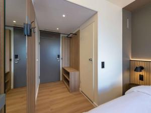 a bedroom with a bed and a walk in closet at ibis Paderborn City in Paderborn