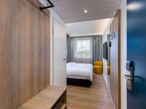a hotel room with a bed and a room with a roomswersswersswersswers at ibis Paderborn City in Paderborn
