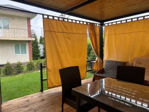 a screened in porch with a table and chairs at Lovely House in Cholpon-Ata