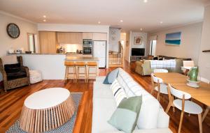 a living room and kitchen with a couch and tables at Flinders Rest in Queenscliff