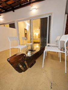 a living room with a wooden table and white chairs at Mayura sea view in Malpe
