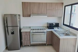 a kitchen with a stainless steel refrigerator and a sink at Tu espacio ideal en Intercity Urban Corridor in Querétaro +10 photos