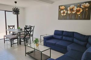 a living room with a blue couch and a table at Tu espacio ideal en Intercity Urban Corridor in Querétaro