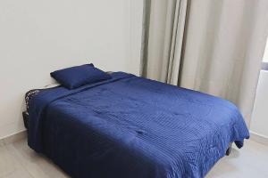 a blue bed in a room with a window at Tu espacio ideal en Intercity Urban Corridor in Querétaro