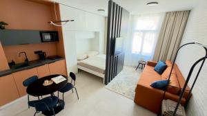 a small room with a bed and a table and chairs at Apartmán Vita Smart in Trenčín