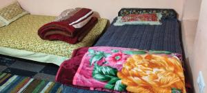 two beds with blankets and pillows sitting in a room at Chaukhamba hill homestay in Ukhimath