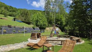 a backyard with two chairs and a fire pit at Domki nad potokiem in Stary Sącz