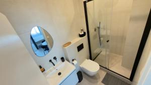 a bathroom with a toilet and a sink and a mirror at Apartmán Vita Smart in Trenčín