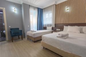 a hotel room with two beds and a chair at Citrus Urban Hotel in Antalya