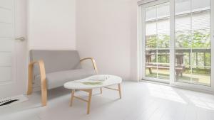 a white living room with a chair and a table at Gapyeong Shiny Pension in Gapyeong +1 photo