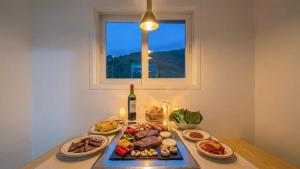 a table with plates of food and a bottle of wine at Gapyeong Shiny Pension in Gapyeong