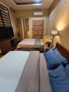 a hotel room with two beds and a television at Nonoy's Haven in Dipolog