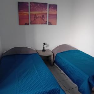 two beds in a room with two pictures on the wall at Family garden house in Limenas
