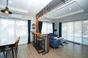a living room with a bar and a blue couch at The One Cozy, Phuket in Chalong