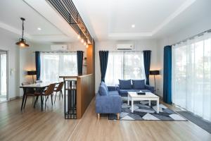 a living room with a blue couch and a table at The One Cozy, Phuket in Chalong