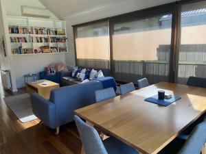 a living room with a table and a couch at Galway Cottage in Queenscliff