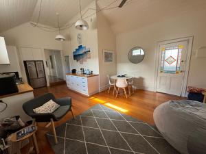 a living room with a bed and a dining room at Galway Cottage in Queenscliff