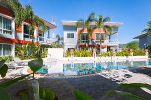 a swimming pool in front of a building at The One Cozy, Phuket in Chalong