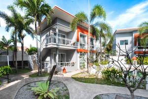a building with palm trees in front of it at The One Cozy, Phuket in Chalong