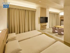 a hotel room with two beds and a table at Hotel Nikko Narita in Narita