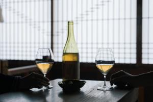 two glasses of white wine and a bottle on a table at CAFE & BB guri in Ine