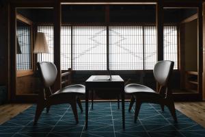 a room with two chairs and a table in front of a window at CAFE & BB guri in Ine