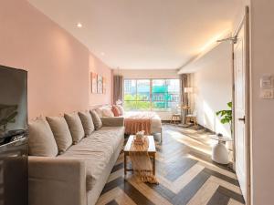 a living room with a large couch and a table at Common Living Iconsiam in Bangkok