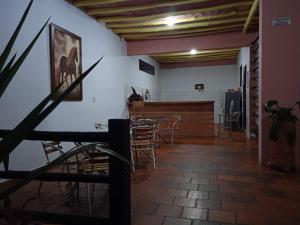 a room with a table and chairs and a bar at Hotel Casona de San Pedro in Curití