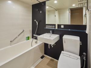 a bathroom with a white toilet and a sink at Hotel Nikko Narita in Narita