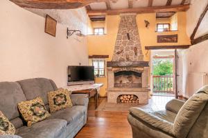 a living room with a couch and a fireplace at Luin Country House near Štanjel - Happy Rentals in Štanjel