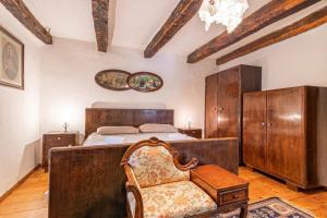 a bedroom with a bed and a chair in it at Luin Country House near Štanjel - Happy Rentals in Štanjel +21 photos