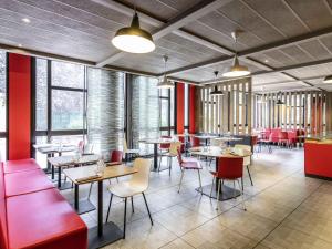 a restaurant with tables and chairs and windows at Ibis Bourges Centre, Hôtel Restaurant in Bourges