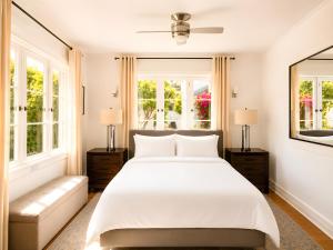 a bedroom with a large white bed and windows at Gloria Palm Springs in Palm Springs +16 photos