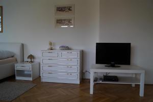 a living room with a tv and a white dresser at Apartmán u stadionu in Broumov