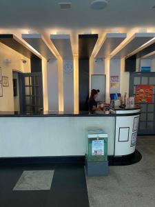 a woman standing at a counter in a store at Nice Hotel Monumento in Manila