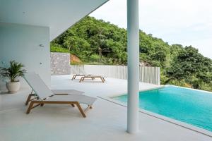an open deck with a swimming pool and a lounge chair at Luxury Villa Infinity Pool Panoramic Seaview Villa Ananda in Ban Thung