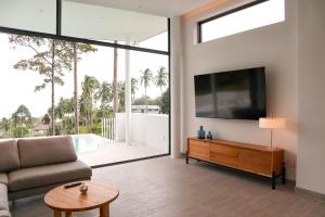 a living room with a couch and a flat screen tv at Luxury Villa Infinity Pool Panoramic Seaview Villa Ananda in Ban Thung