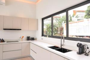 a kitchen with white cabinets and a large window at Luxury Villa Infinity Pool Panoramic Seaview Villa Ananda in Ban Thung