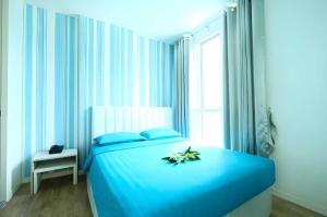 ein blaues Beet mit einer Blume darauf in der Unterkunft Sunday Beachfront View Jomtien Pattaya in Jomtien Beach