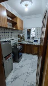 a kitchen with a refrigerator and a stove at Sweet Inn Limbe in Limbe